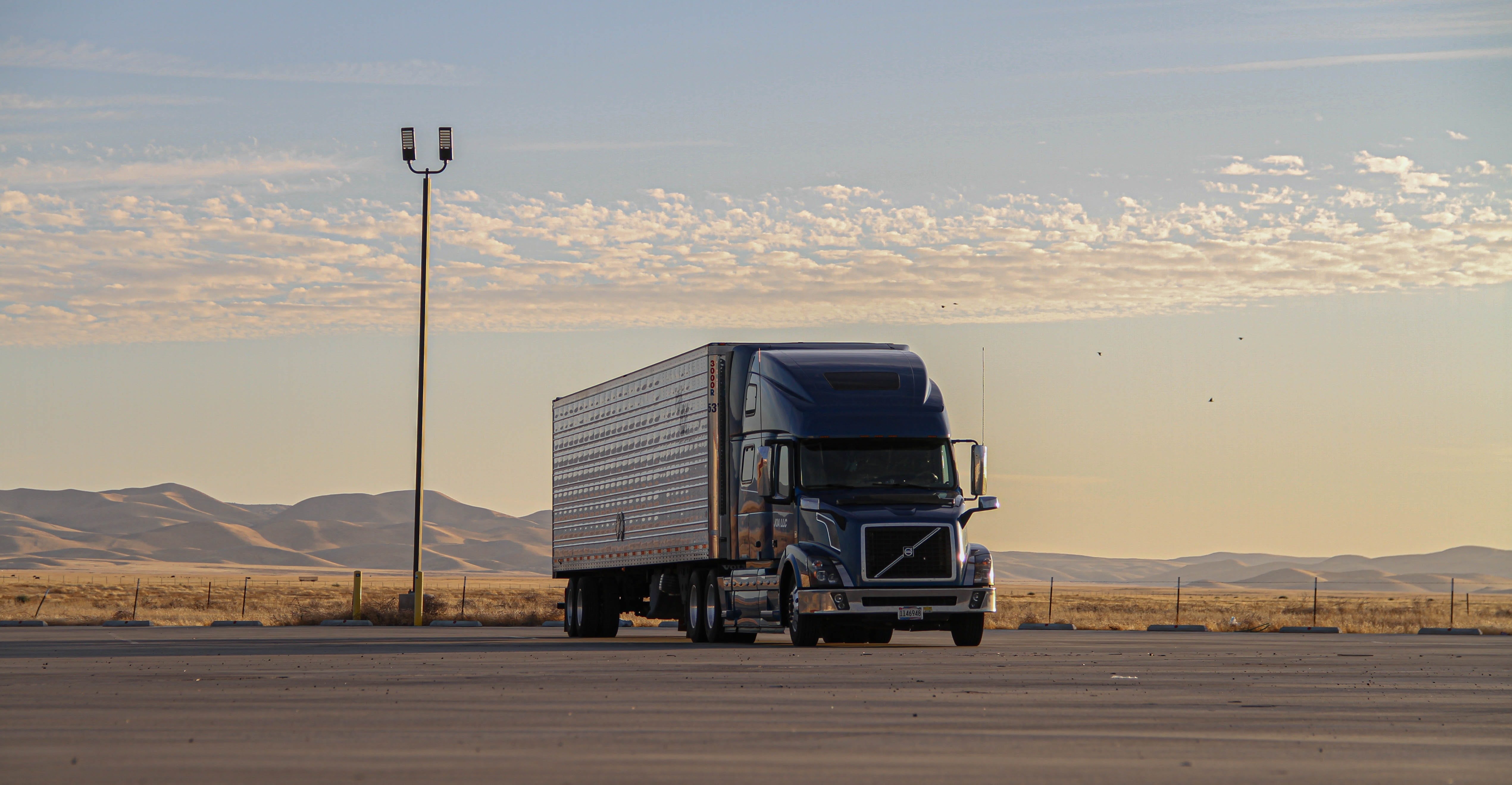 truck and trailer parked in empty parking lot